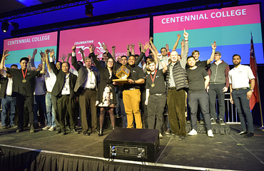An excited group of Centennial College Ontario Skills Competators award winners on stage